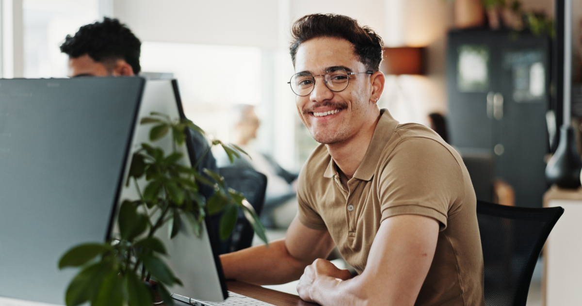 Een glimlachende man werkt op een computer