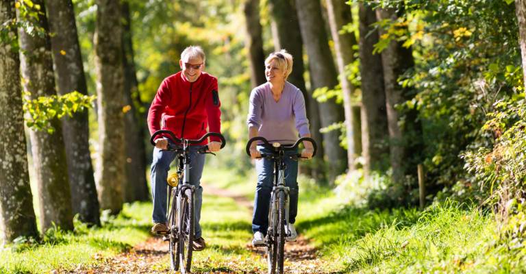 Ouder stel fietst door het bos